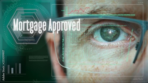 A close up of a businessman eye controlling a futuristic computer system with a Mortgage Approved Business concept. photo