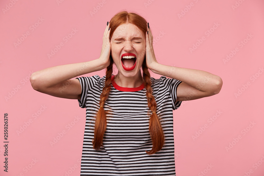 Ταπετσαρία Angry young red-haired girl in stripped t-shirt, keeps closed eyes, closes her e