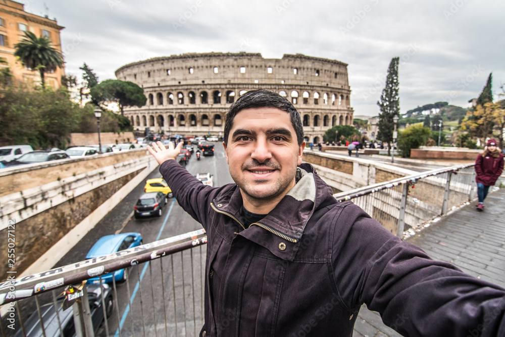 Αυτοκόλλητο Young pretty man at colosseum taking selfies with smartphone in Rome city centre