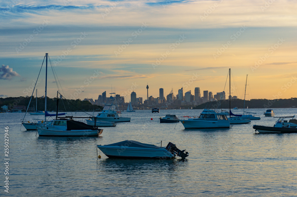 Yachts and boats with Sydney CBD on the background on sunset