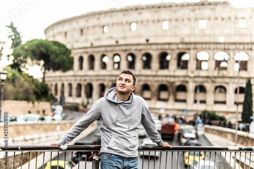 Photography Young man tourist standing in front of Colosseum in Rome, Italy