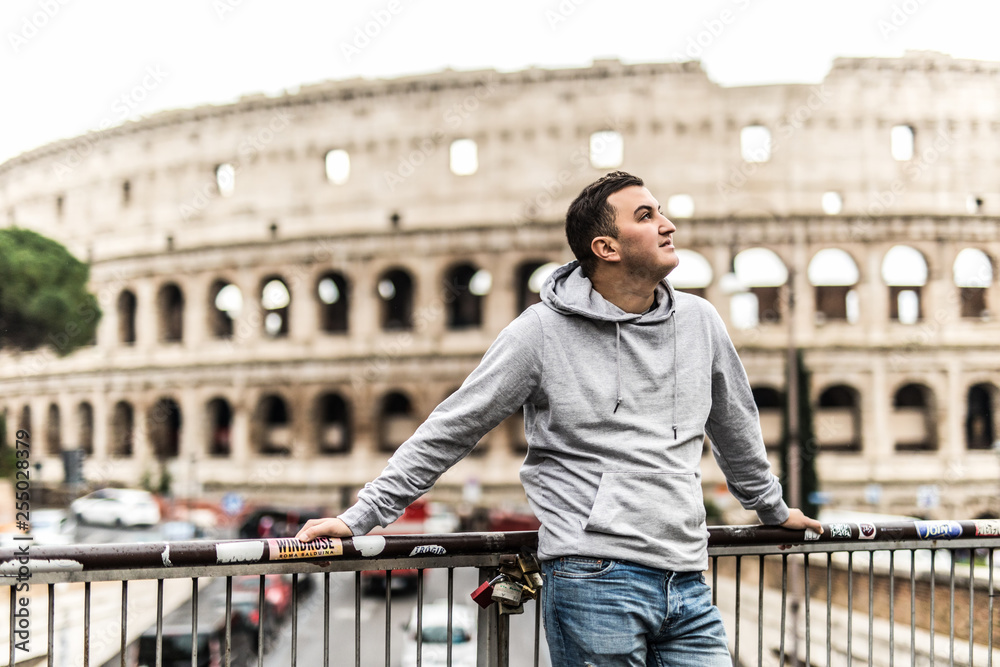 Φωτογραφία Young man travel standing on the street in Rome with Colosseum on background