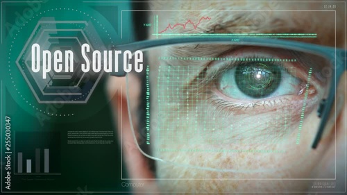 A close up of a businessman eye controlling a futuristic computer system with a Open Source Business concept. photo