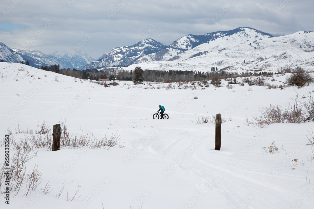 Woman riding fat bike in snowy mountains