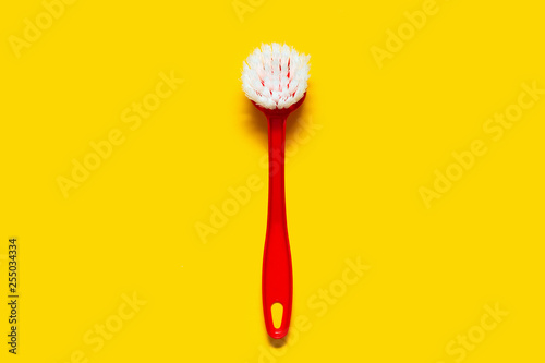 Bright red brush lies on a bright yellow background. In the style of pop art. Top view. Copy space.