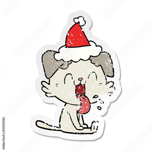 distressed sticker cartoon of a panting dog wearing santa hat