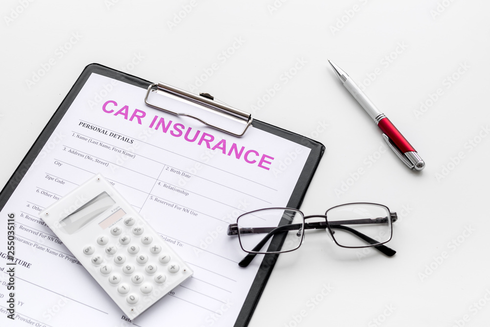 Car insurance form near glasses, calculator, pen on white background Car insurance form near glasses, calculator, pen on white background