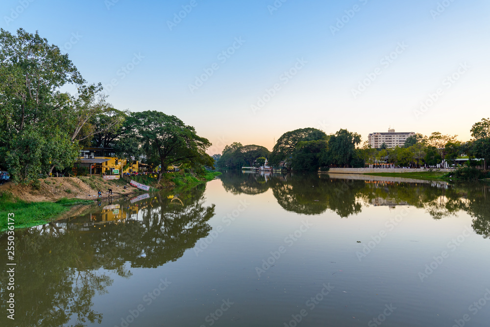 Fototapeta premium Outdoor tranquil natural scenery of rural riverside Ping river with calm and reflected water in Chaing Mai, Thailand. 