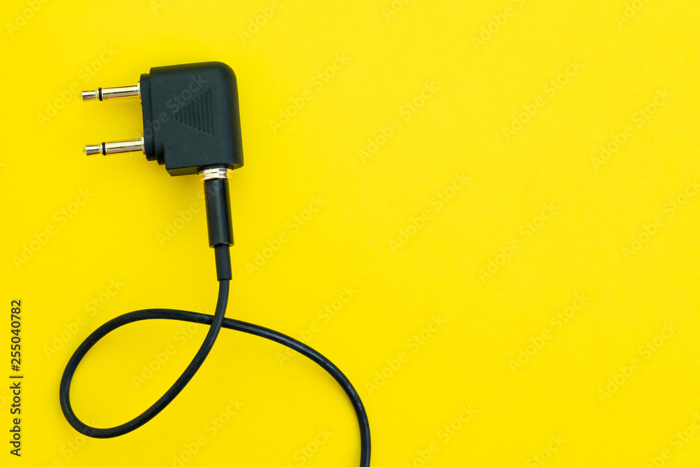 Flat lay of topview of headphone audio jack with 2 legs and black cable using in airplane, preparing for travel and tourist concept Flat lay of topview of headphone audio jack with 2 legs and black cable using in airplane, preparing for travel and tourist concept
