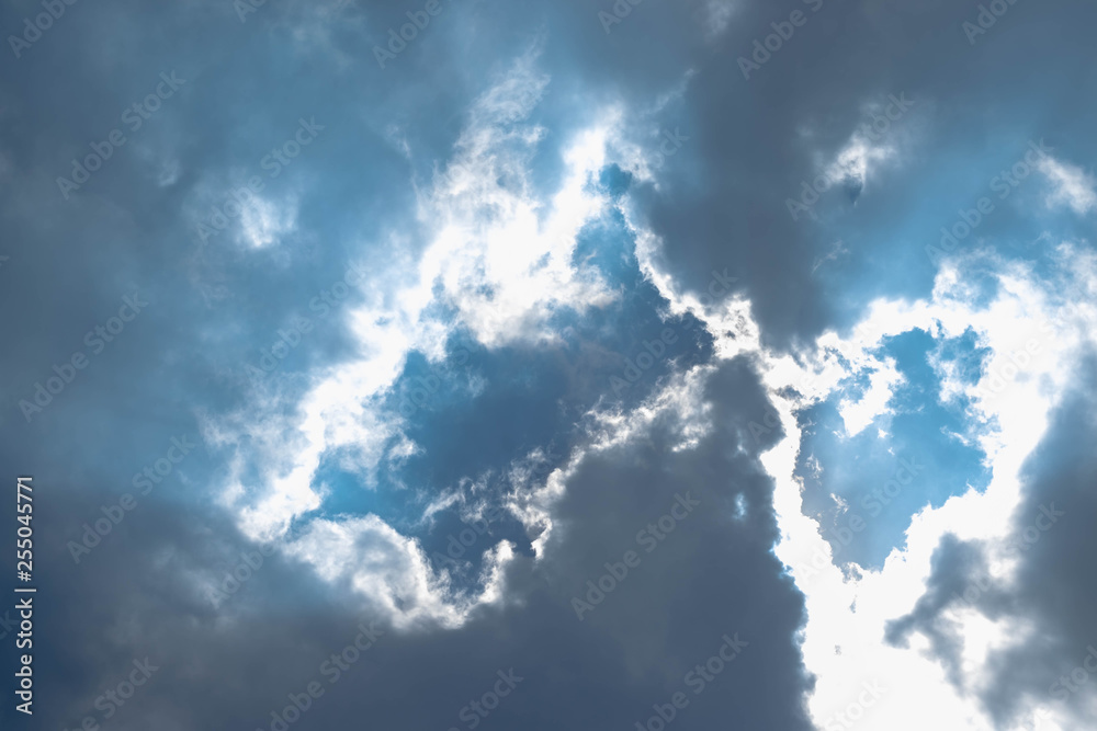 Blue sky with white clouds and gray cloud blue sky on a bright day with white clouds coming in floating come to cover sun causes a white beam causing beauty in the sky. Blue sky with white clouds and gray cloud blue sky on a bright day with white clouds coming in floating come to cover sun causes a white beam causing beauty in the sky.