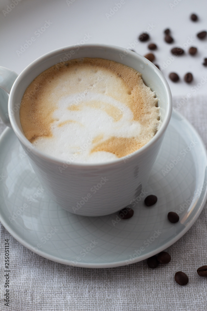 cup of cappuccino, coffee in a cup on a napkin close-up. cup of cappuccino, coffee in a cup on a napkin close-up.