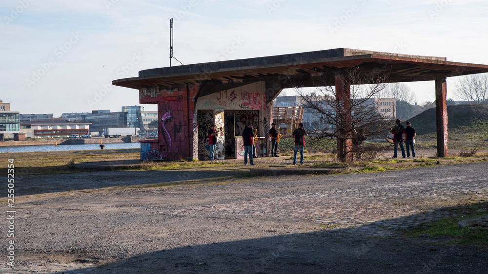A group of musicians rehearses in an abandoned area of a port
