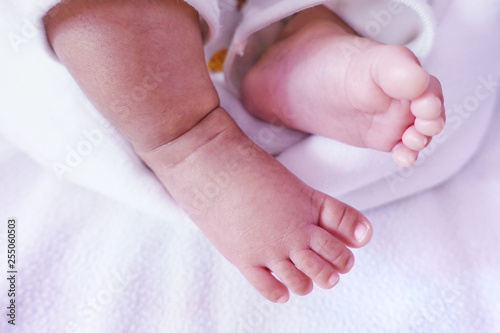 Newborn baby feet under the white blanket