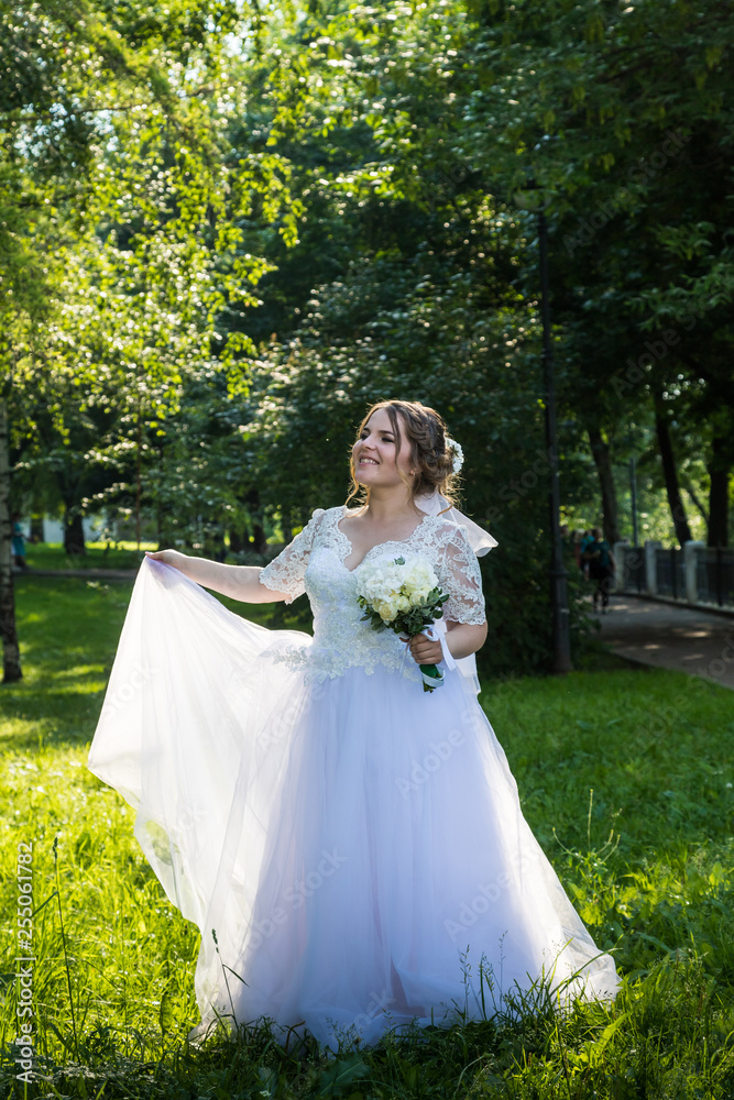 Russian bride dancing in green city park