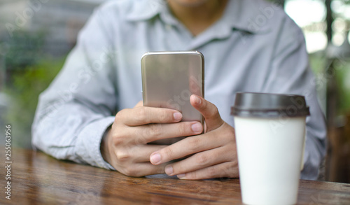 man using smart phone in cafe