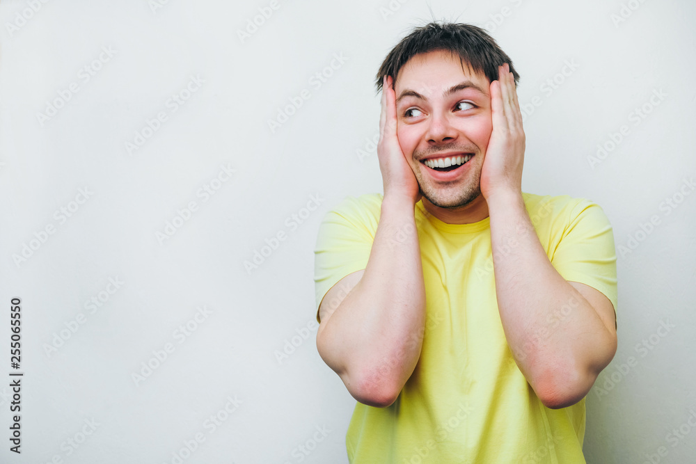 Excited overjoyed man feel happy looking on copy space, euphoric winner holds his head in his hands, with a mad, stunned, hungry look. celebrating win victory success triumph isolated at white grey Excited overjoyed man feel happy looking on copy space, euphoric winner holds his head in his hands, with a mad, stunned, hungry look. celebrating win victory success triumph isolated at white grey