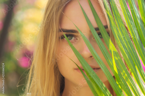 Фотография close up portrait face blond woman thick eyebrows like Cara Delevingne with palm