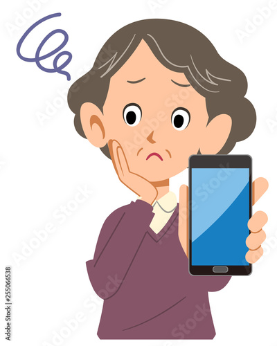 スマートフォンを手に持ち閃くシニアの女性