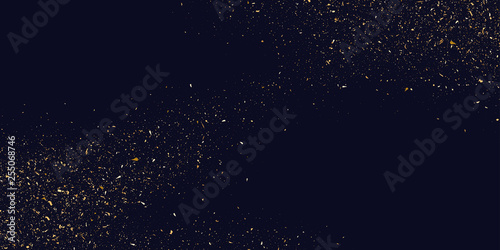Gold glitter. Shiny particles on a dark background.