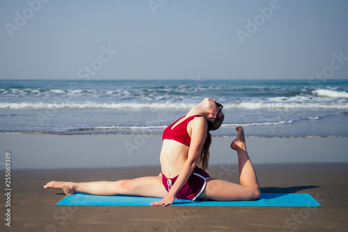 Fotografie muladhara swadhisthana manipula tantra yoga on the beach woman meditates sitting on the sand yoga mat by the sea at summer morning