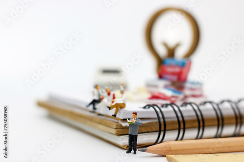 Miniature people: Business team reading book, education or business concept.
