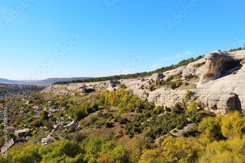 Limestone cliffs rises above the valley and the old part of the city of Bakhchisarai in the autumn on the Crimean peninsula.
