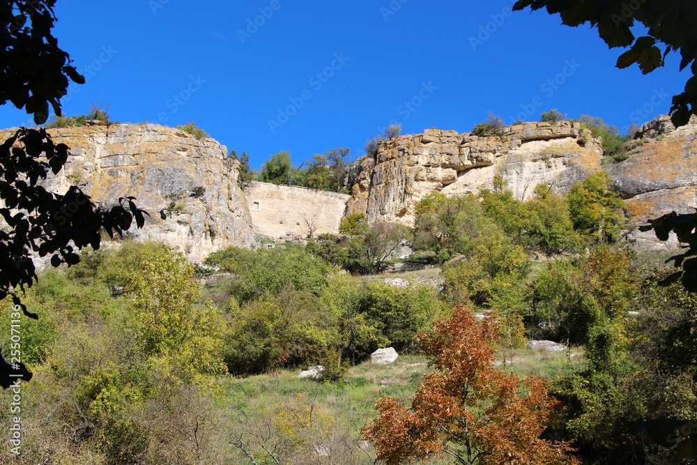 View from the valley on the cavetown Chufut-Kale in the autumn near Bakhchisarai city on the Crimean Peninsula. It'is a medieval city-fortress in the Crimean Mountains that now lies in ruins.