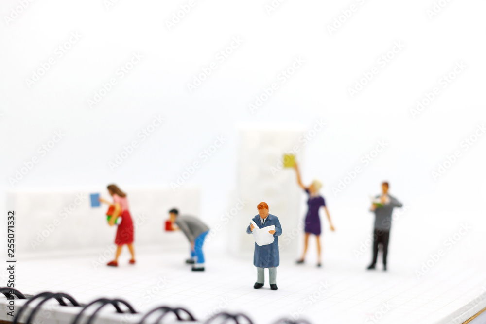 Miniature people: Business team reading book, education or business concept. Miniature people: Business team reading book, education or business concept.