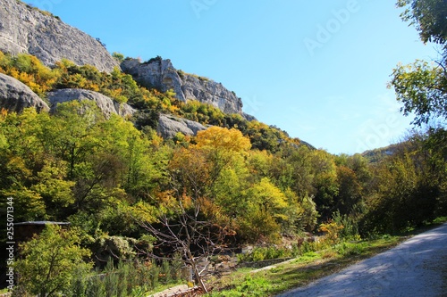 In clear weather, the rock rises above the colorful autumn forest