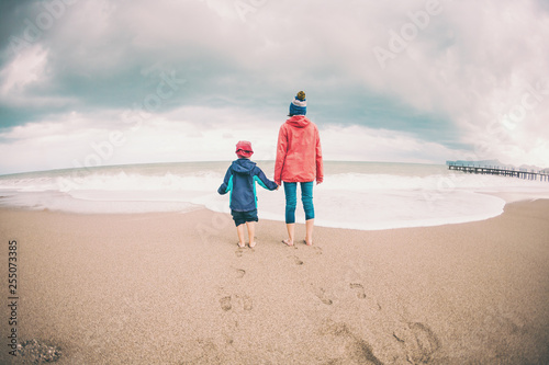 Barefoot boy with mother come into the sea.