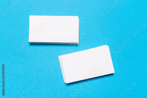 Blank white business cards on blue background. Mockup for branding identity.
