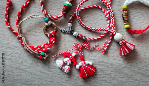 Bulgarian traditional spring decor martenitsa bracelets, wooden background. Baba Marta holiday, backdrop.