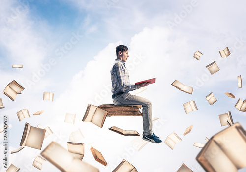 Man reading book and many of them flying in air