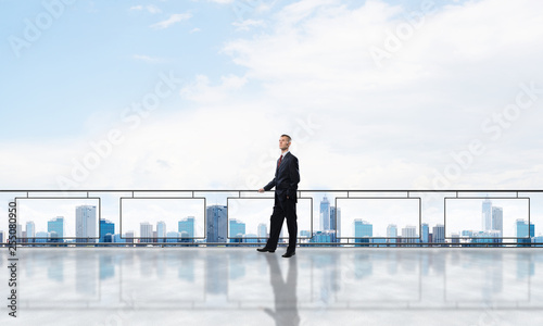 Sunrise above skyscrapers and businessman facing new day