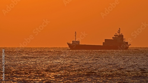 夕焼けに染まる明石海峡と貨物船の情景 © Scott Mirror