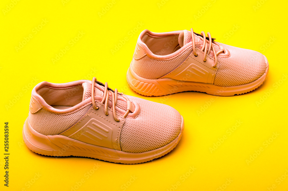 Kid's fashion pink boots on color background. Stylish new shoes on yellow background. Kid's fashion pink boots on color background. Stylish new shoes on yellow background.