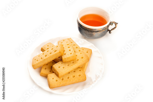 A photo of Scottish shortbreads, butter cookies on a white background with a vintage tea cup and copy space