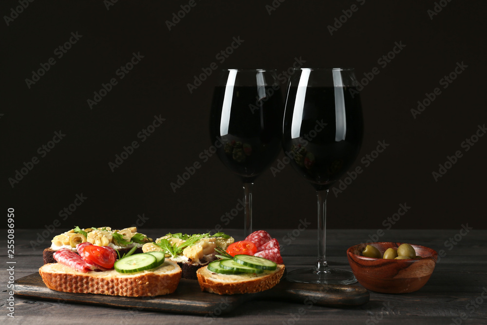 Glasses of red wine with tasty bruschettas on table Glasses of red wine with tasty bruschettas on table
