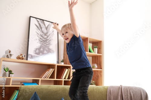 Happy little boy jumping at home