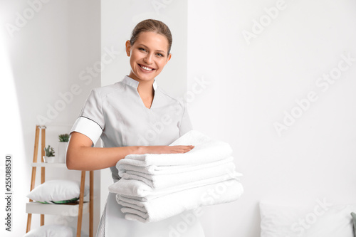 Bild auf Leinwand Beautiful female housekeeper with clean towels in room