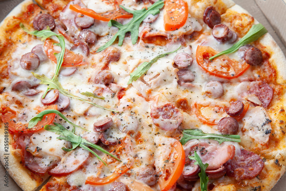 Round tasty pizza in a cardboard box with home delivery. Round tasty pizza in a cardboard box with home delivery.