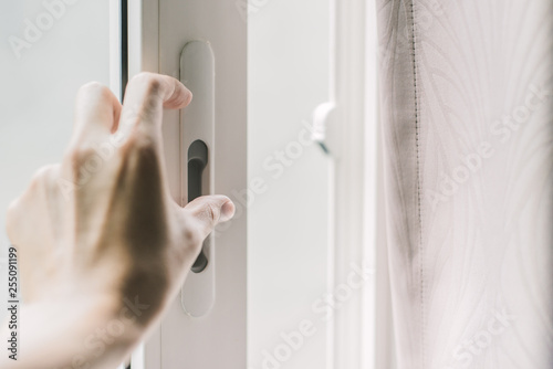 Close up of hand holding lock mirror door to open or close at home.