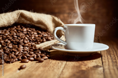 Czarna kawa na starych deskach i rozsypane ziarna