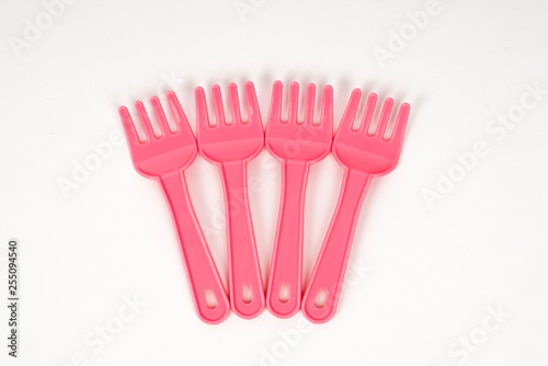 Pink plastic baby fork on a white background isolated