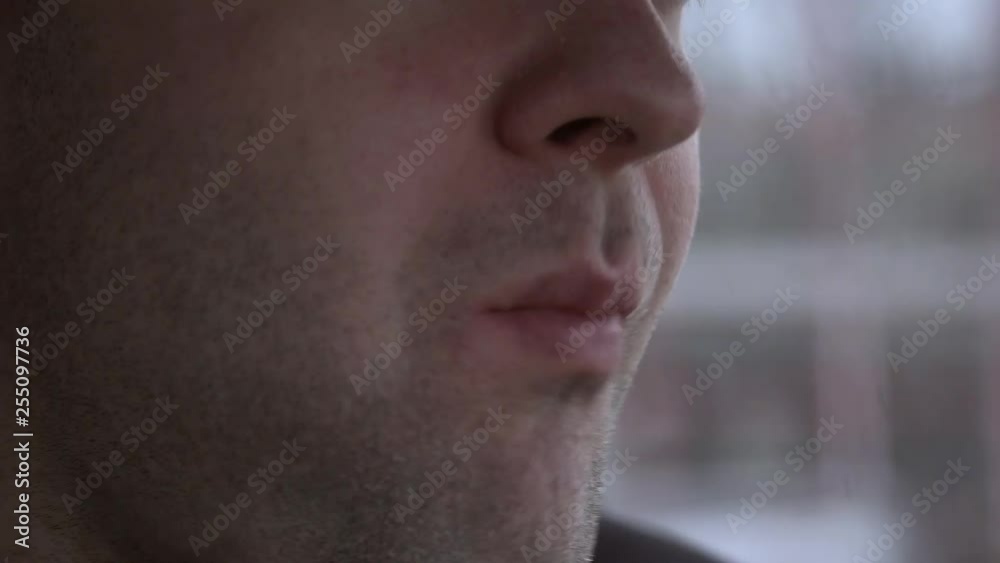 Close up of man quickly eats burger during working break in cafe Close up of man quickly eats burger during working break in cafe