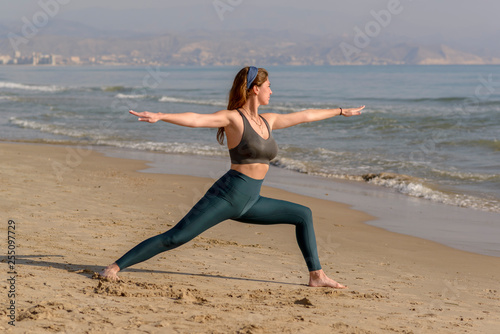 Chica haciendo yoga en la playa