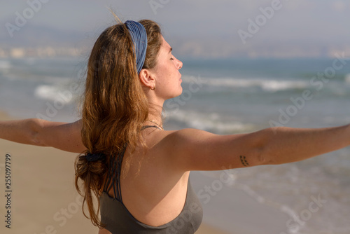 Chica haciendo yoga en la playa