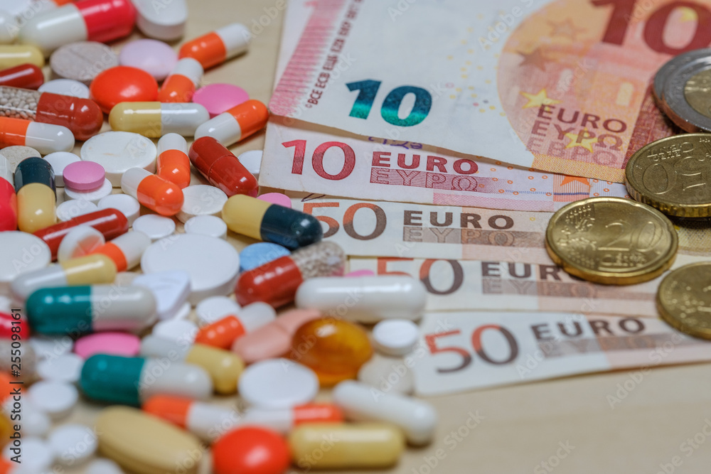 Euro bills and colored pills on a light background. Tablets money concept. Euro bills and colored pills on a light background. Tablets money concept.