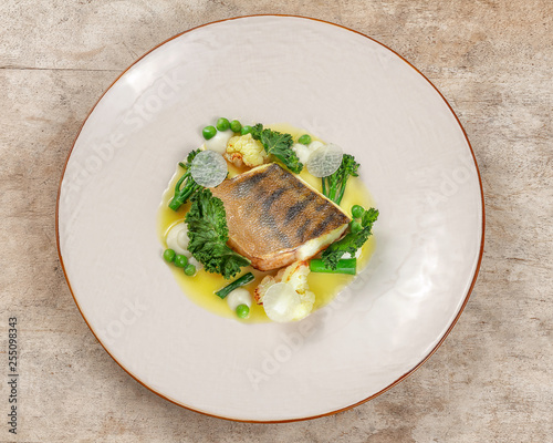 Overhead shot of pikeperch on a white plate with ligth garnish