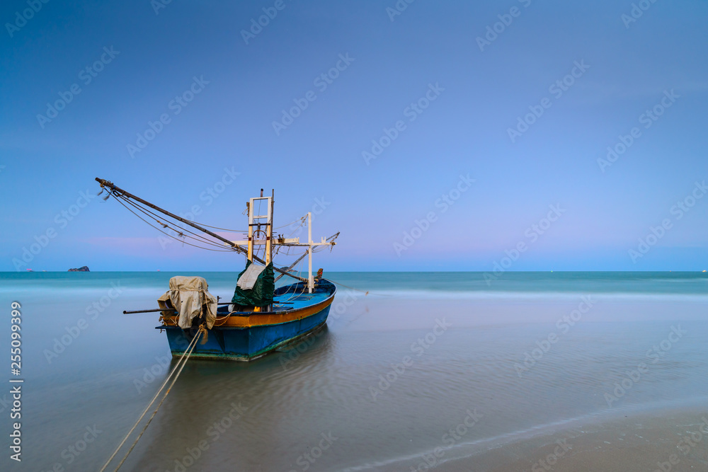 Wooden fishing boat on the beach after sunset at Kao Tao, Prachuap Khiri Khan, Thailand.